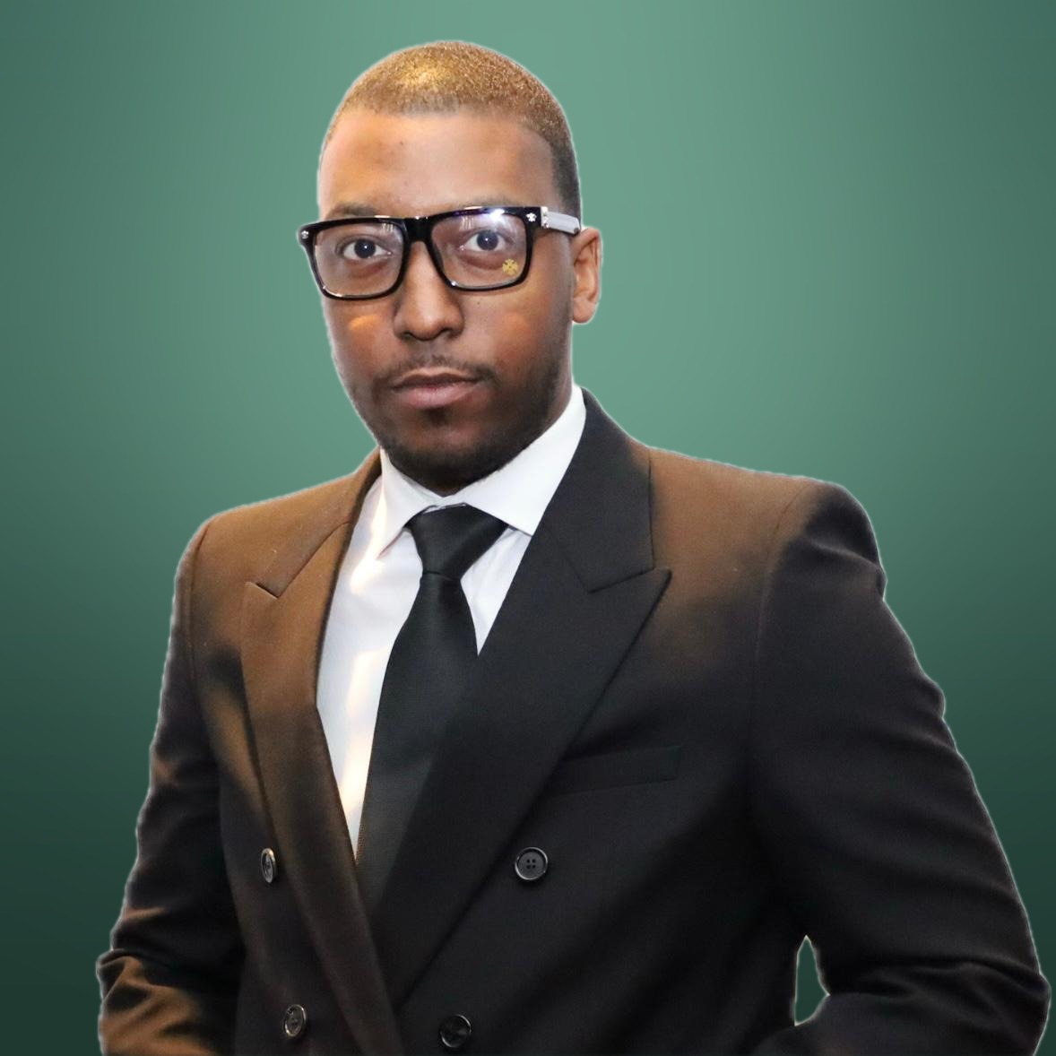 Aton Williams in a dark suit and glasses
